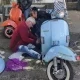 two people are repairing a scooter