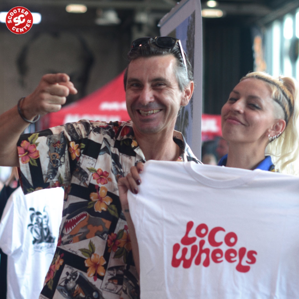 two happy people showing a white shirt with loco wheels logo