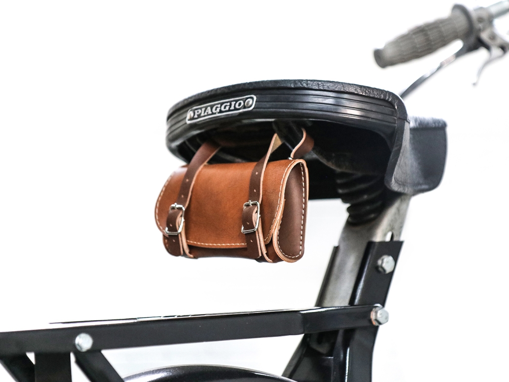 small brown tool bag on the back of a moped
