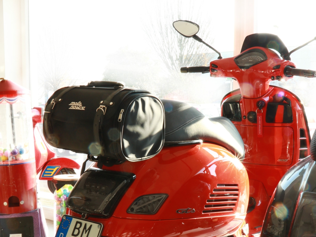 Red Vespa GT with the suitcase on the luggage rack
